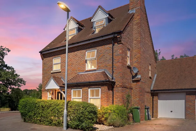 Red-brick detached house photographed at dusk